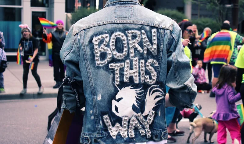 A person holding a sign reading "born this way", representing authenticity in brand marketing