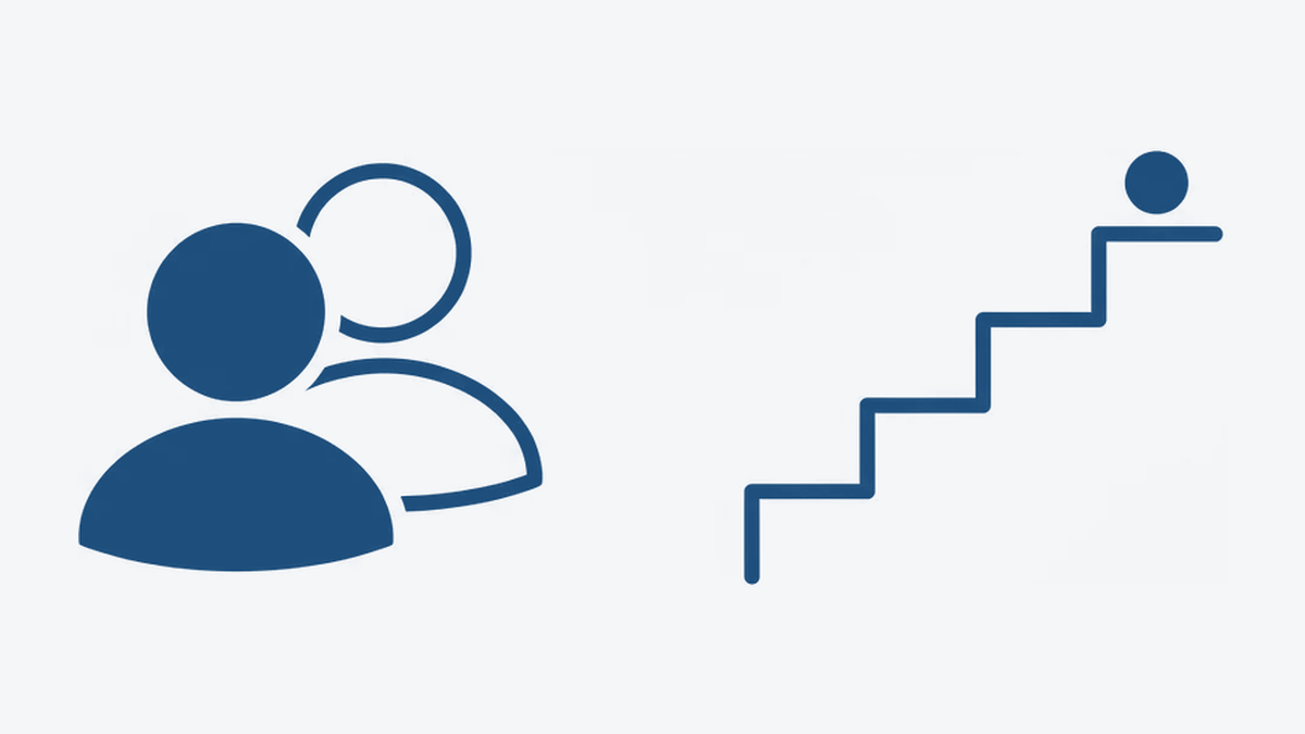 Two people side by side, and beside them an ascending staircase with the goal resting on its top step